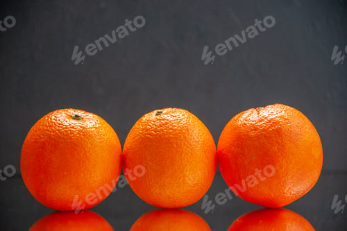 Preview: Front view of fresh oranges standing side by side on black background with free space