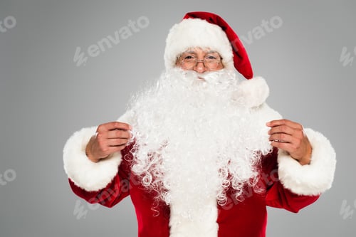 Preview: Santa claus in eyeglasses and hat looking at camera isolated on grey