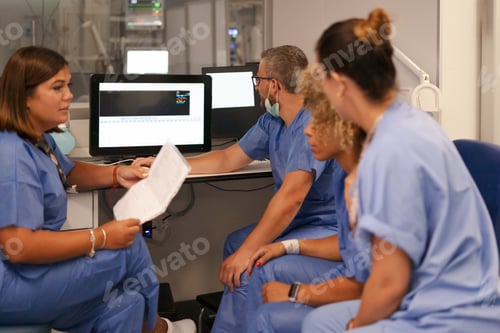 Preview: Medical team collaborating analyzing patient data on monitor