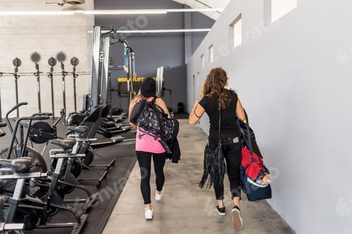 Preview: Two women holding gym bag walking indoors