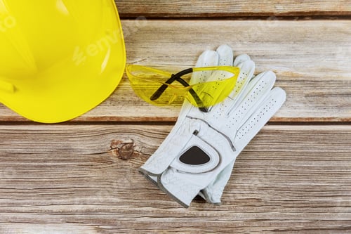 Preview: Yellow helmet in construction, protective gloves, glasses working tools on wooden board
