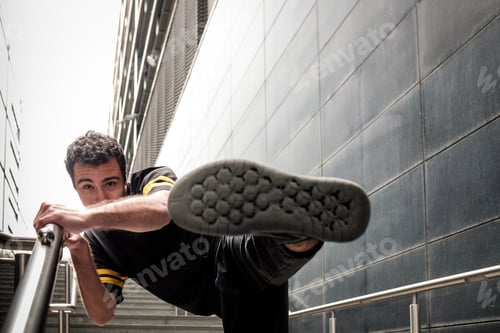 Preview: Young man dancer performing dancing close to modern building.