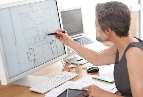 Preview: A mature female architect working on building plans on her touchscreen computer