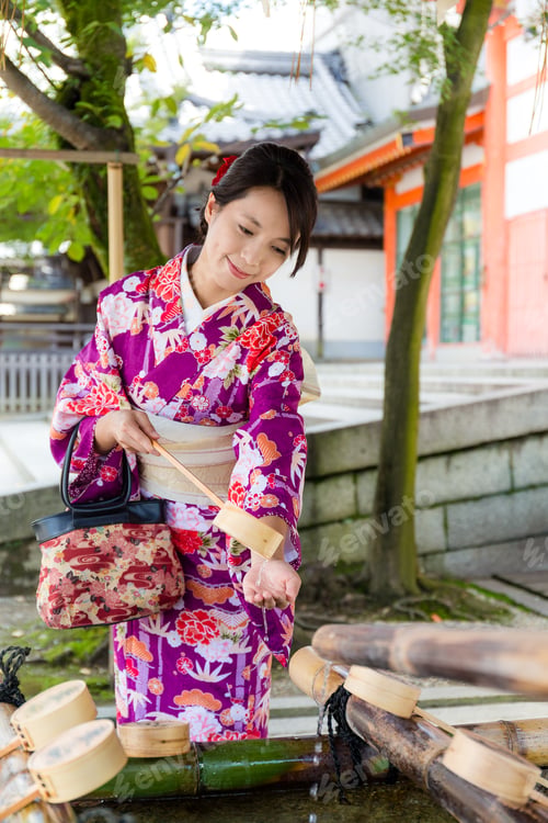 Preview: Young japanese woman use of the bamboo ladle in water fountain
