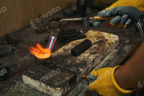 Preview: Goldsmith holding crucible with precious metal during smelting