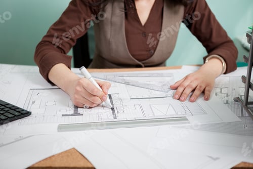 Preview: Architect woman at her table drawing on blueprints