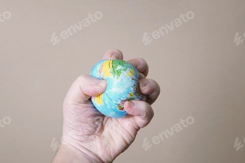 Preview: hand crushing globe of planet earth - ecocide or destruction of environment concept