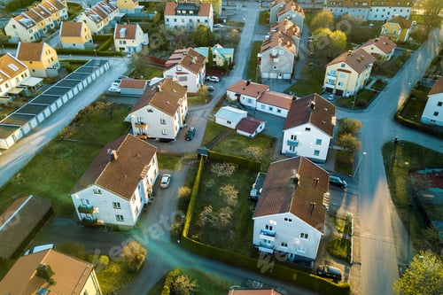 Preview: Aerial view of residential houses with red roofs and streets with parked cars in rural town