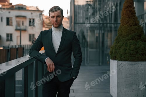 Preview: Handsome man in formal clothes is outdoor near the business building
