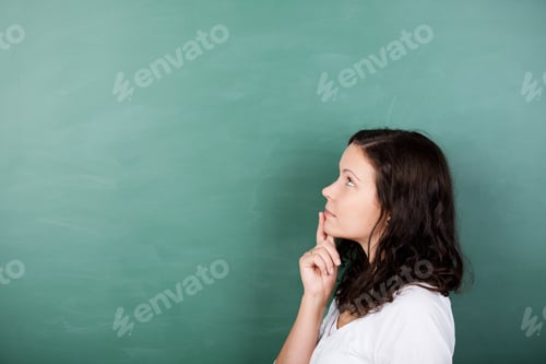 Preview: Attractive Young Female Student Standing Solving A Problem Staring Thoughtfully Up Into The Air