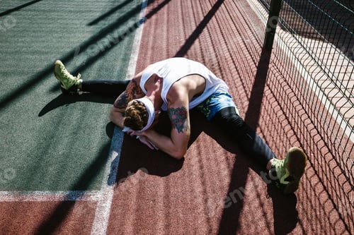 Preview: Young athletic man with white headband, dressed in the white t-shirt, black leggings and blue shorts