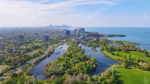 Preview: High angle shot of Jackson Park with blossomed trees and a lake with skyscrapers in the background