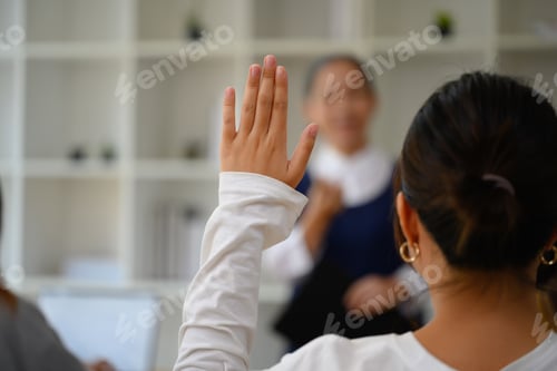 Preview: Back view of female college student raising hand to answering a question during lecture