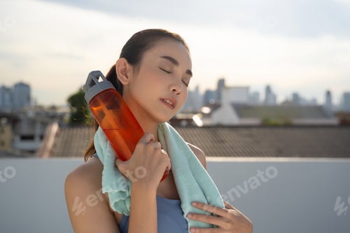 Preview: Young Asian woman resting after running exercise.outdoor exercise fitness concept