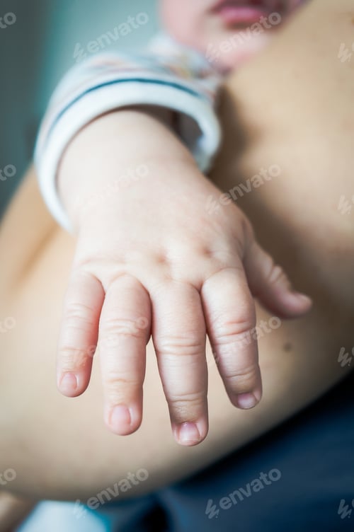 Preview: Vertical shot of babies hand and mother's arm