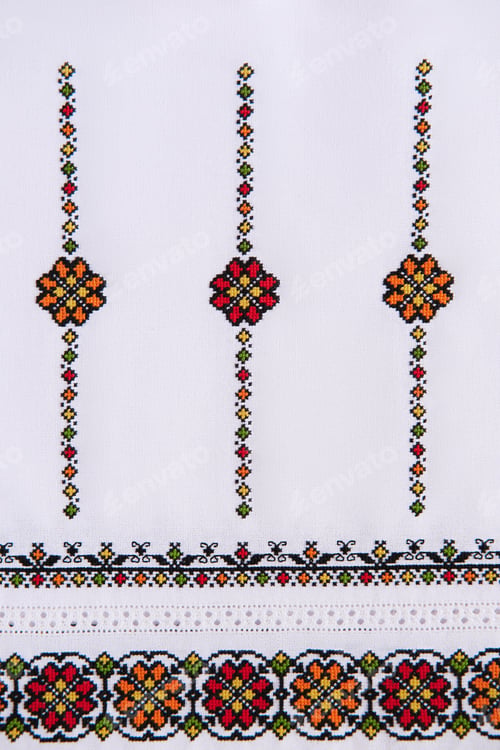 Preview: Texture of linen white fabric with embroidered element. Ukrainian embroidery pattern for folk shirt.