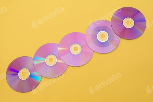 Preview: Several purple compact discs on a yellow background, creating a vibrant and nostalgic visual