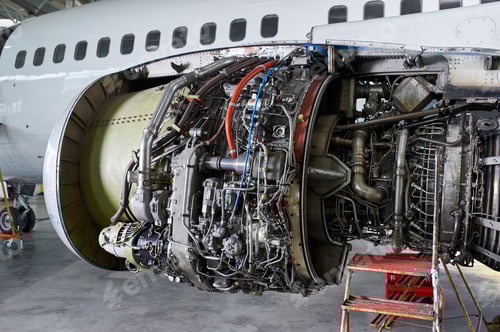 Preview: aircraft engine servicing - opened panels of a large engine of parked aircraft.