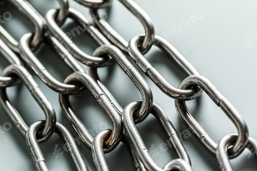 Preview: Metal chains are arranged on a flat surface in a simple layout during daytime light