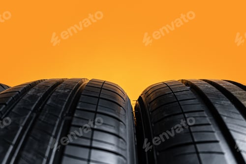 Preview: Car tires isolated on yellow background, close up