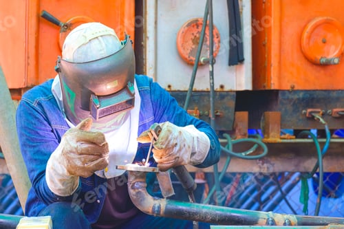 Preview: Welder welding metal flange for using as improvement material in oil pipeline systems work