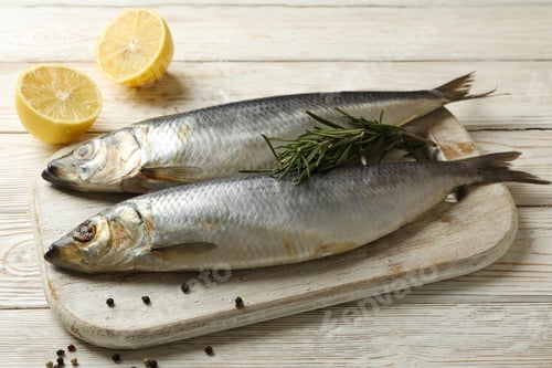 Preview: Board with fresh herring fish on white wooden background
