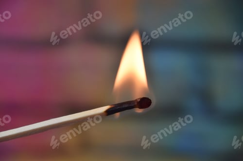 Preview: a burning match stick and colourful blurry background