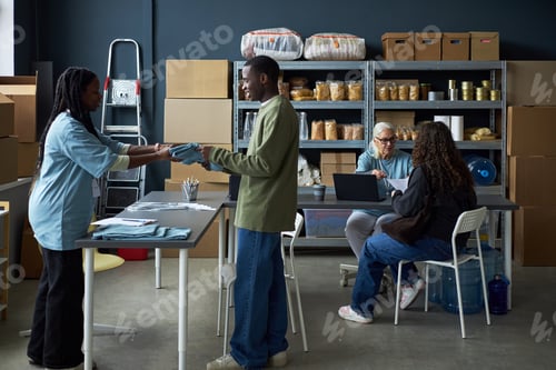 Preview: Diverse Group Discussing Work in Storage Room Setting