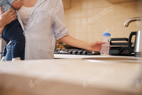 Preview: Close up of female hand taking bottle