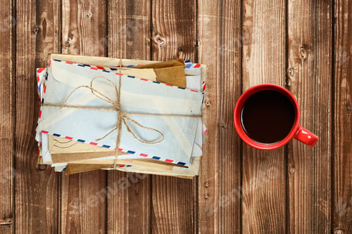 Preview: Pile of old envelopes and coffee cup on wooden table top view