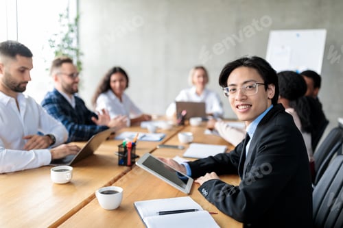 Preview: Asian Businessman Using Digital Tablet Attending Corporate Meeting In Office