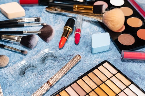 Preview: set of decorative cosmetics, makeup brushes on a blue background. the view from the top