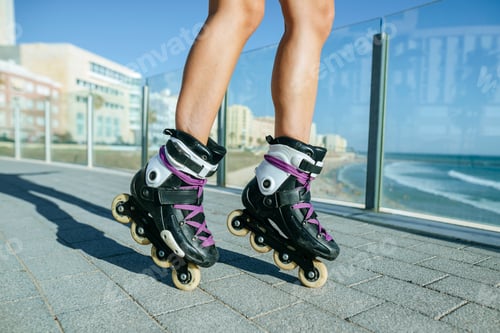 Preview: Woman roller skating on promenade by the sea enjoying summer day