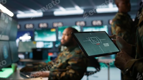 Preview: Military agent working in control room, using software on tablet
