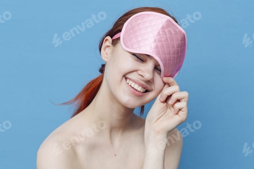 Preview: cheerful woman with a medical mask on her head on a blue background looks to the side