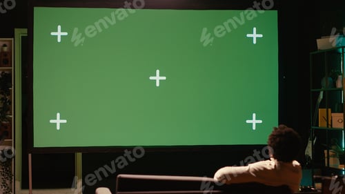 Preview: Man zapping through green screen TV channels using remote, relaxing on couch