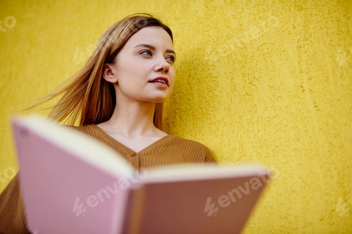 Preview: Thoughtful woman with opened notebook