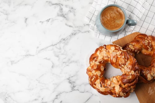 Preview: Delicious pastries and coffee on marble table, flat lay. Space for text