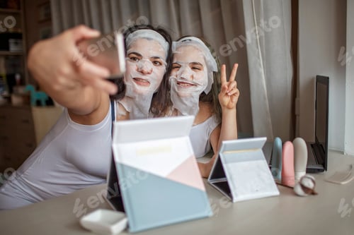 Preview: Girl and her mother using gadgets during spa procedure, mom and daughter chatting via internet
