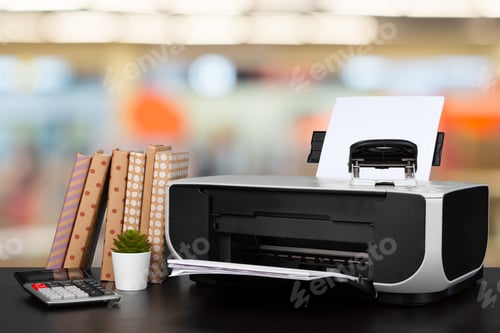 Preview: Compact home printer on desk with books against blurred background