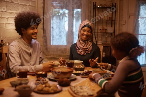 Preview: Happy Middle Eastern family enjoying in meal at dining table.