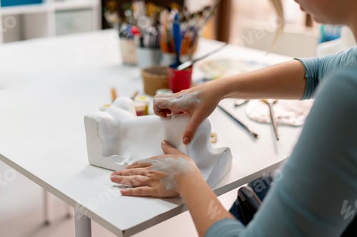 Preview: a young female sculptor learning how to make sculpture, making a human nose
