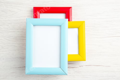 Preview: Overhead view of three empty picture frames in different colours on stripped background