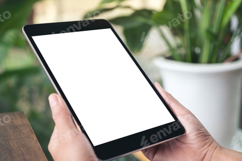 Preview: Mockup image of hands holding black tablet pc with blank white screen while sitting in cafe
