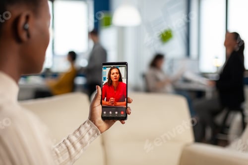 Preview: Over the sholder of black employee discussing with partner on video call