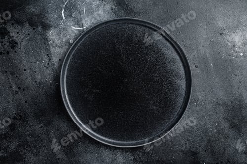 Preview: Empty black craft plate on table. Table setting. Black background. Top view. Copy space
