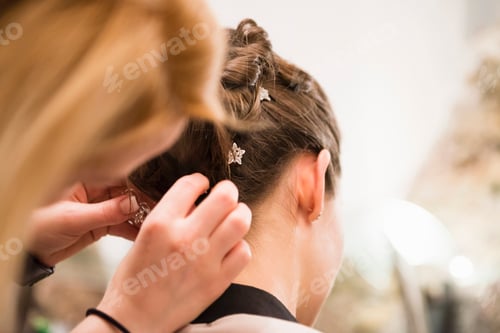 Preview: Close up of woman placing hair decoration into brides hair