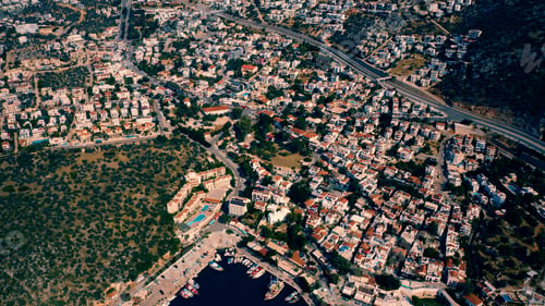 Preview: Scenic aerial view of coastal town cityscape by sea and mountains.