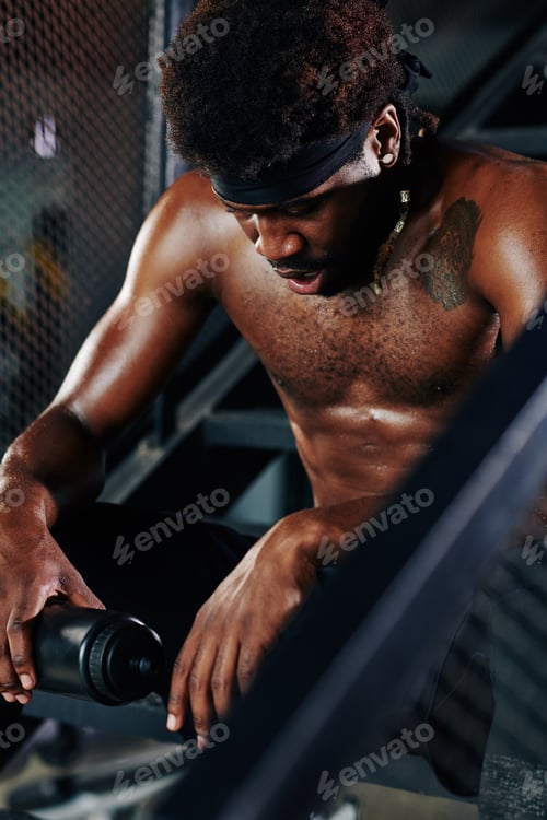 Preview: Muscular man resting on metal steps
