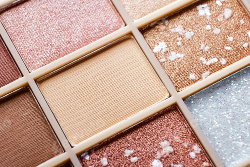 Preview: Eyeshadow colorful shades palette in beige tones close-up. Beauty abstract background